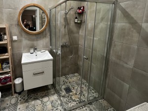 Зеркало в деревянной раме в интерьере ванной комнаты с подсветкой